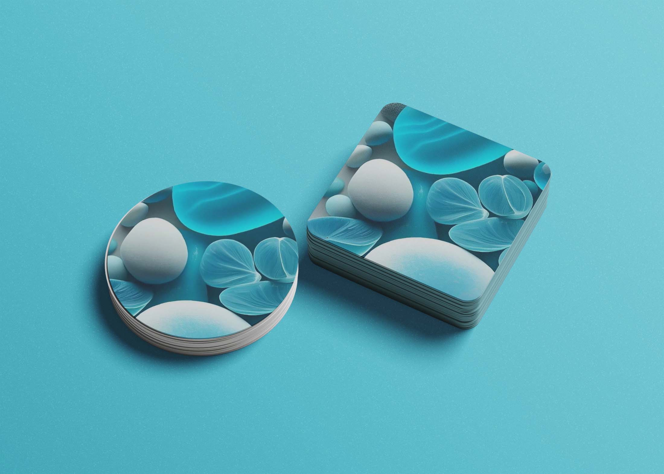 A round paper coaster and a stack of rectangular coasters feature abstract blue and white designs on a light blue backgr