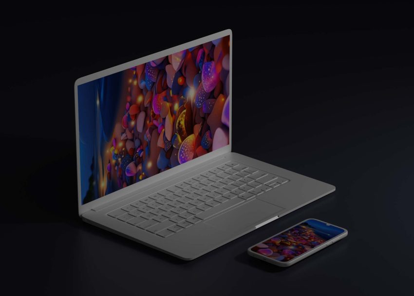 A silver laptop with a vibrant, colorful abstract wallpaper sits next to a smartphone displaying a similar design.